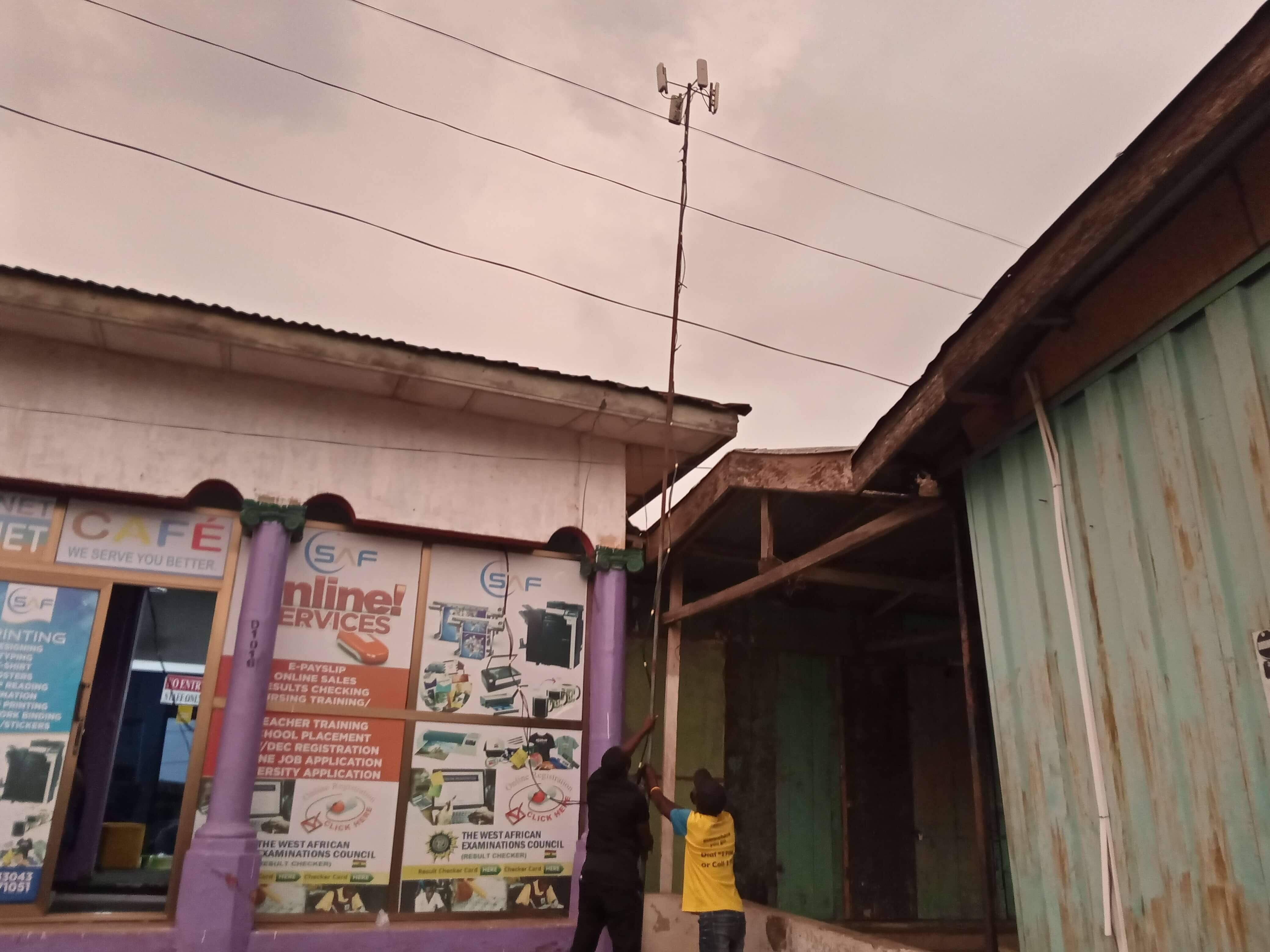 Technicians installing the mast above the Geoponet Cafe