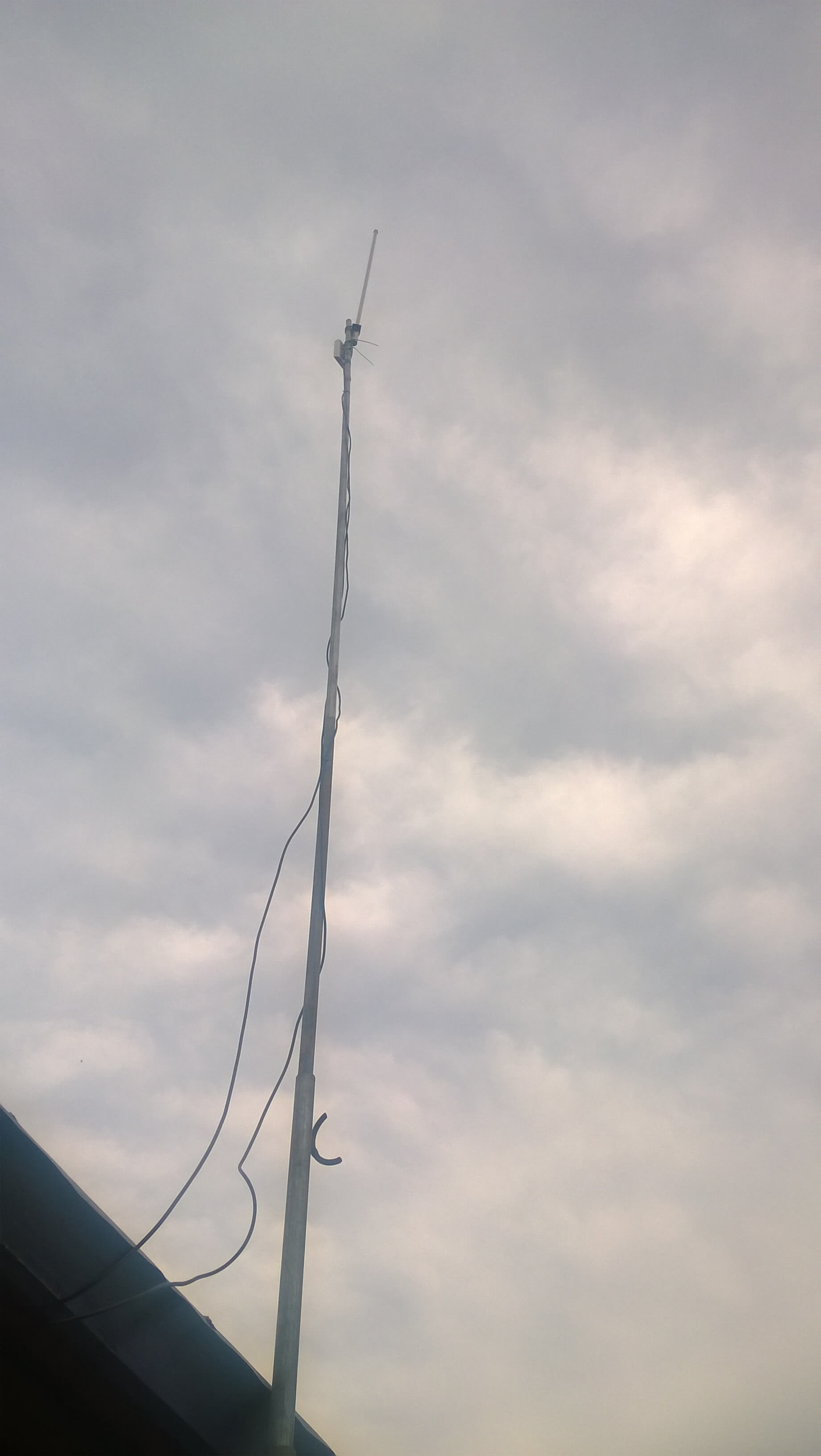 Mast and antenna against a cloudy sky